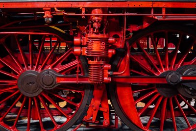 Nahansicht von roten Eisenbahnrädern auf einer schwarzen Lok