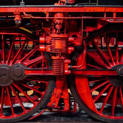 Nahansicht von roten Eisenbahnrädern auf einer schwarzen Lok
