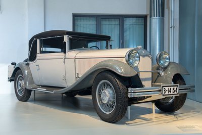 Die Karosserie des NAG Protos 208 ist weiß lackiert, die weit geschwungenen Kotflügel sind grau lackiert. Das Auto hat eine sehr lange Kühlerhaube und zwei große, runde Scheinwerfer vor dem Kühlergrill. Das Verdeck ist schwarz und lässt sich zurückschieben.