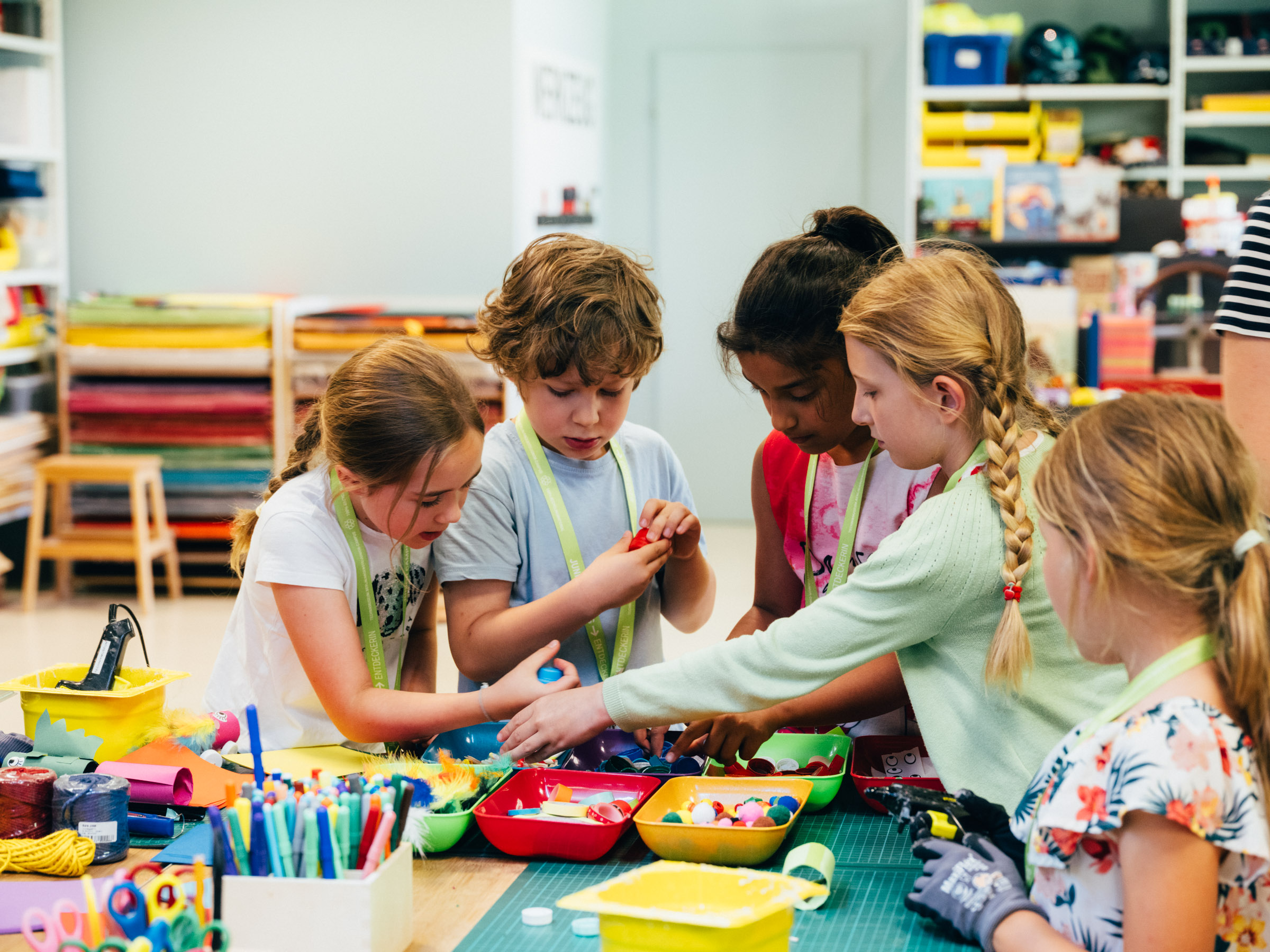 Eine Gruppe von Kindern arbeitet zusammen an einem Basteltisch.