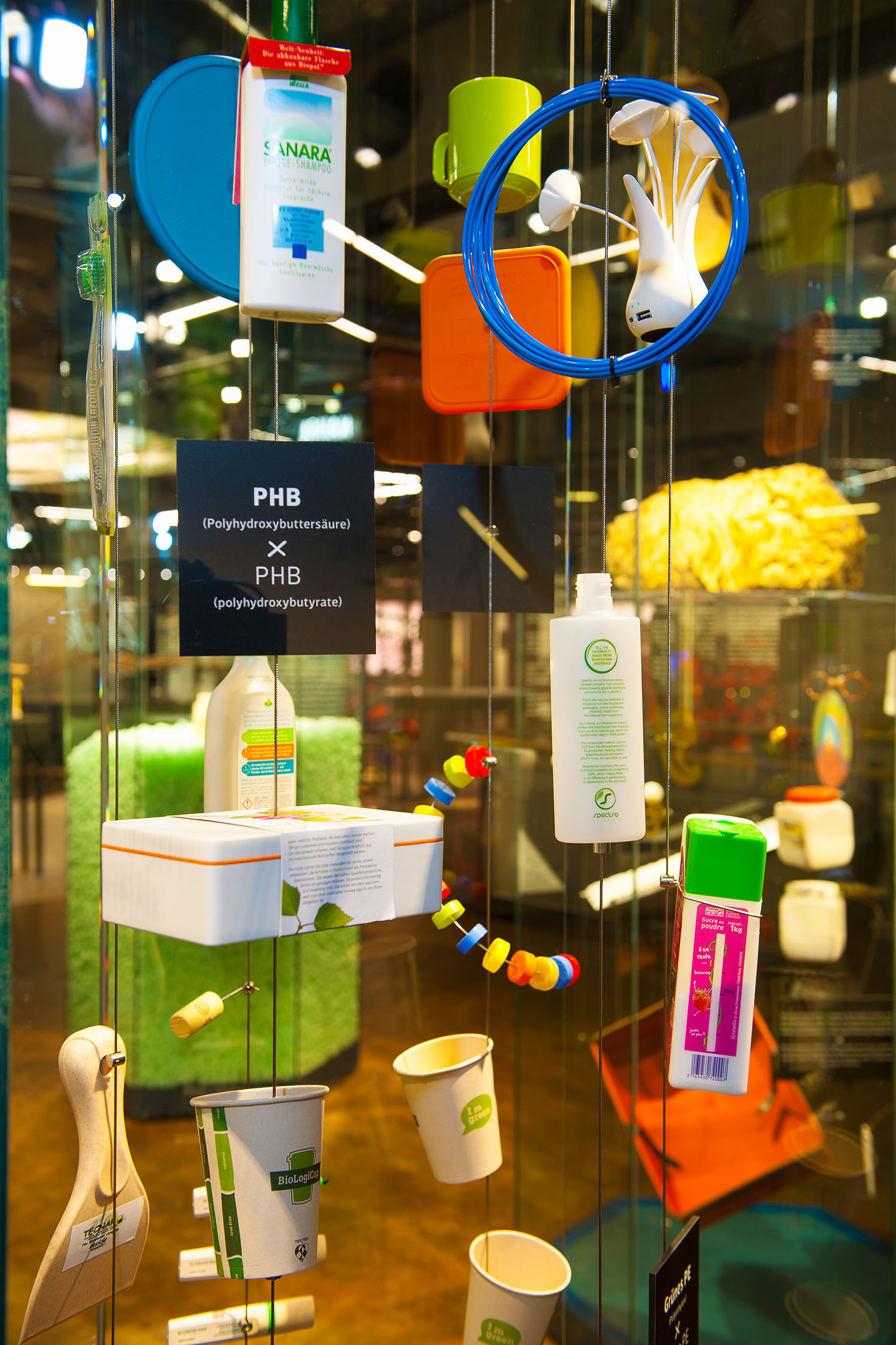 Eine Vitrine mit Dingen des täglichen Bedarfs, die aus Zuckern hergestellt wurden: beispielsweise Kaffeebecher, Stifte, Spülmittelverpackungen oder Korken.