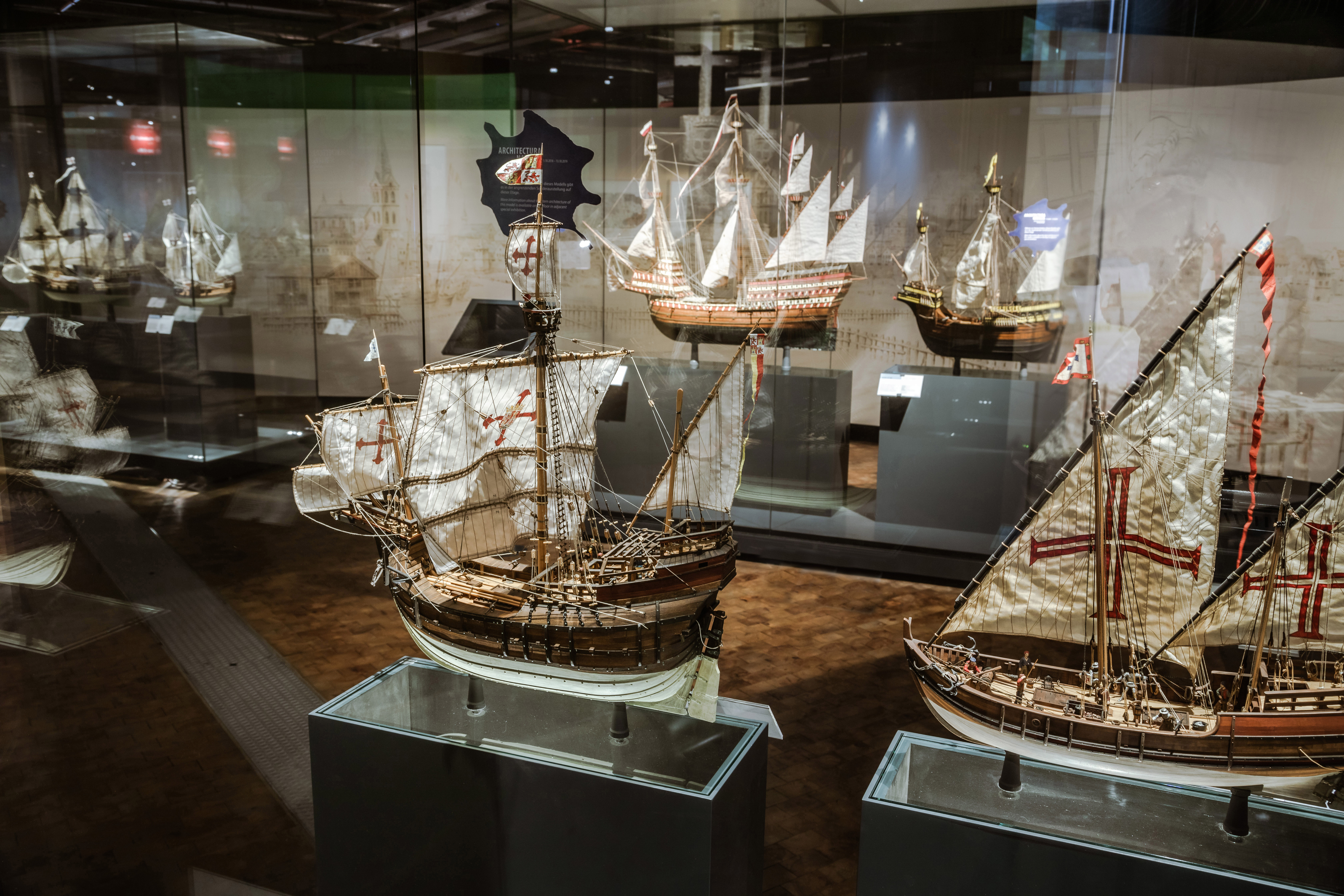 Ein mit Vitrinen gesäumter Gang, darin verschiedene Modelle von Segelschiffen.